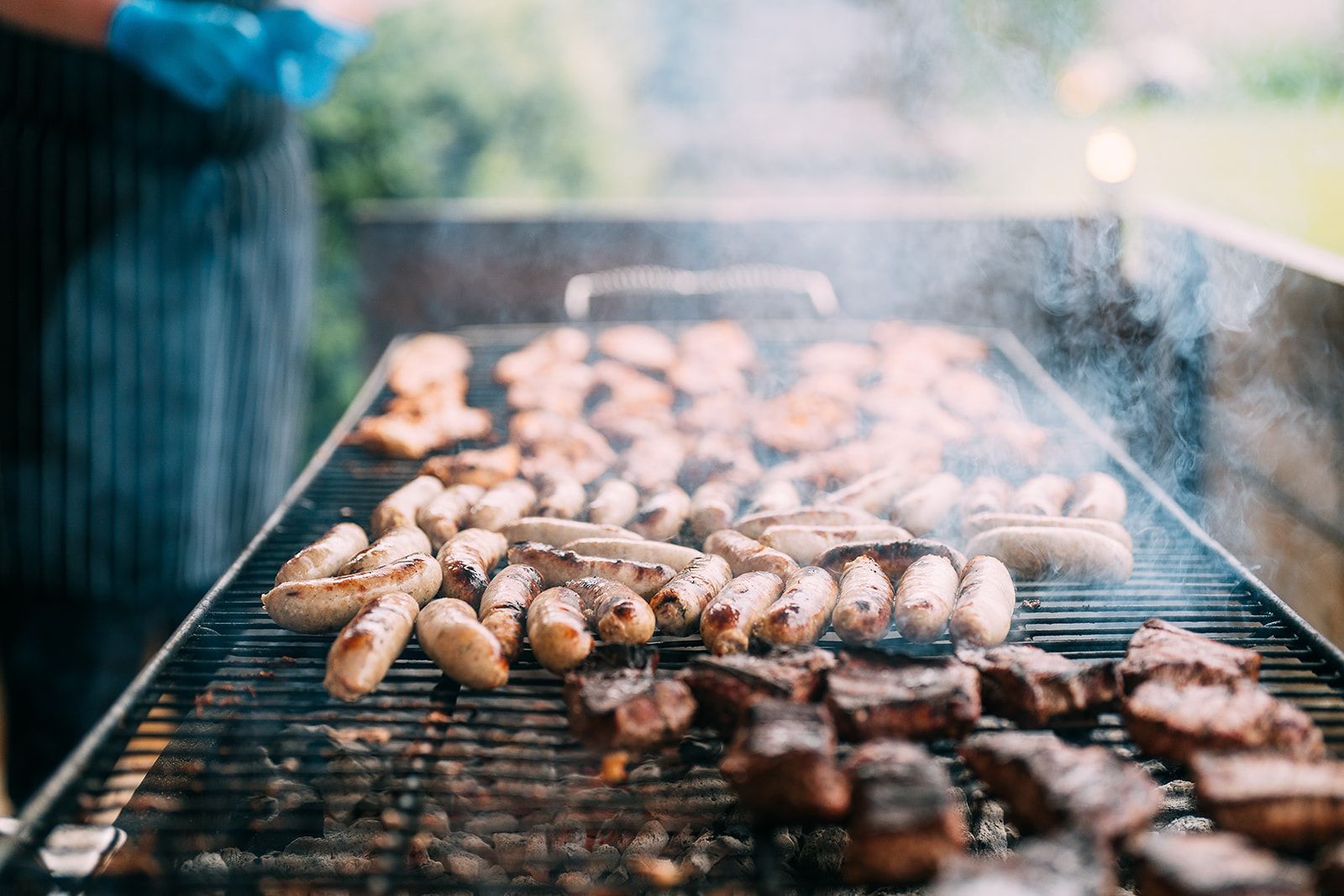 A bunch of meat is cooking on a grill.