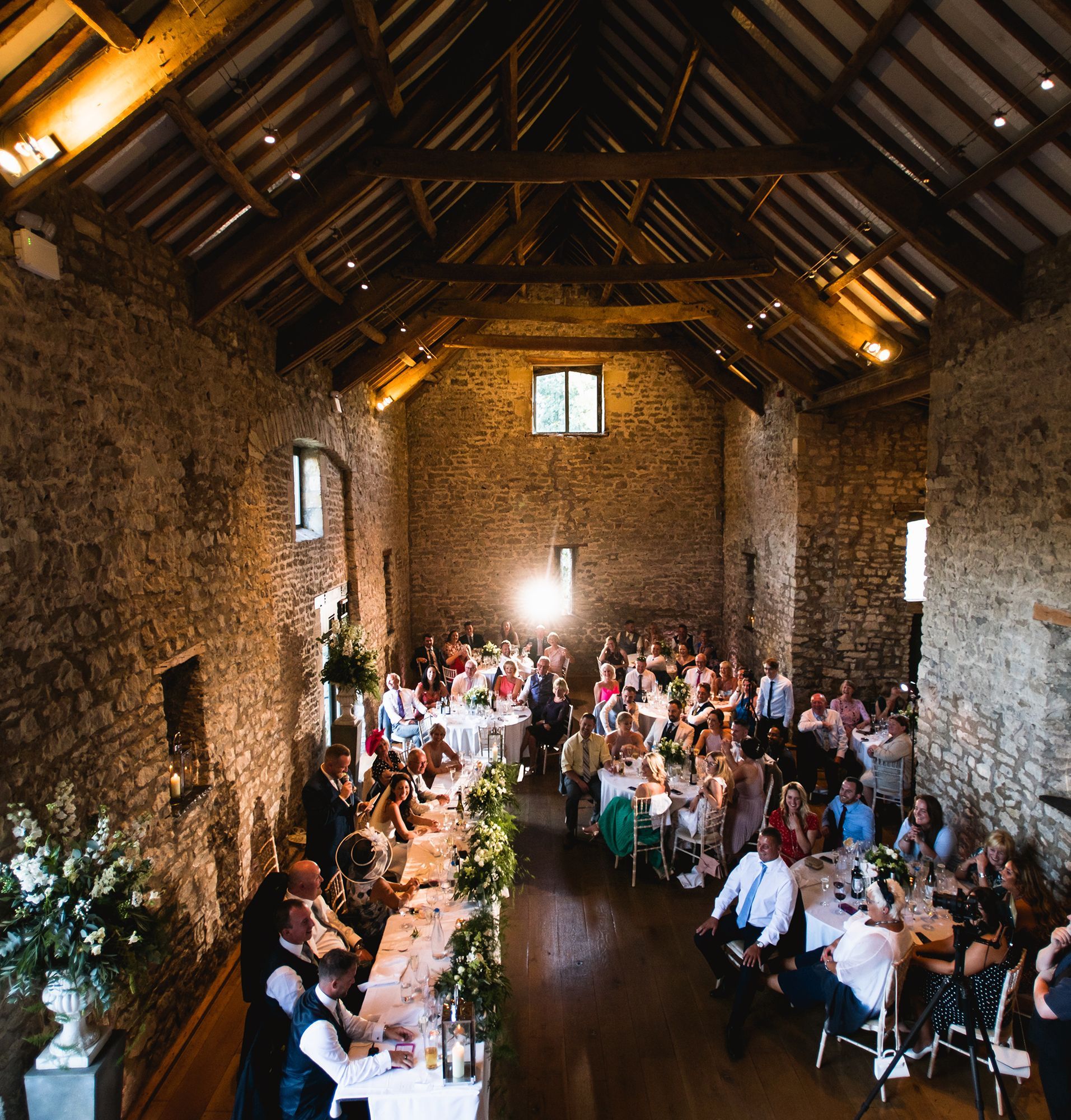 A large group of people are sitting at long tables in a large room