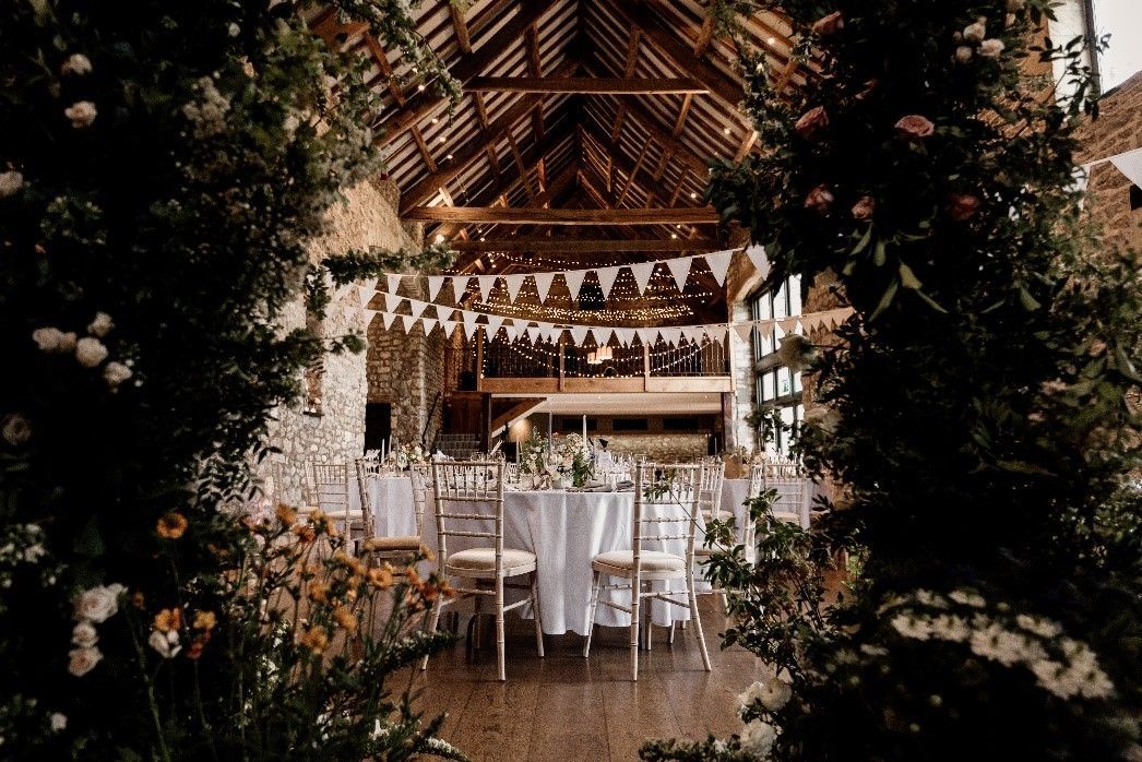 A large room with tables and chairs set up for a wedding reception.