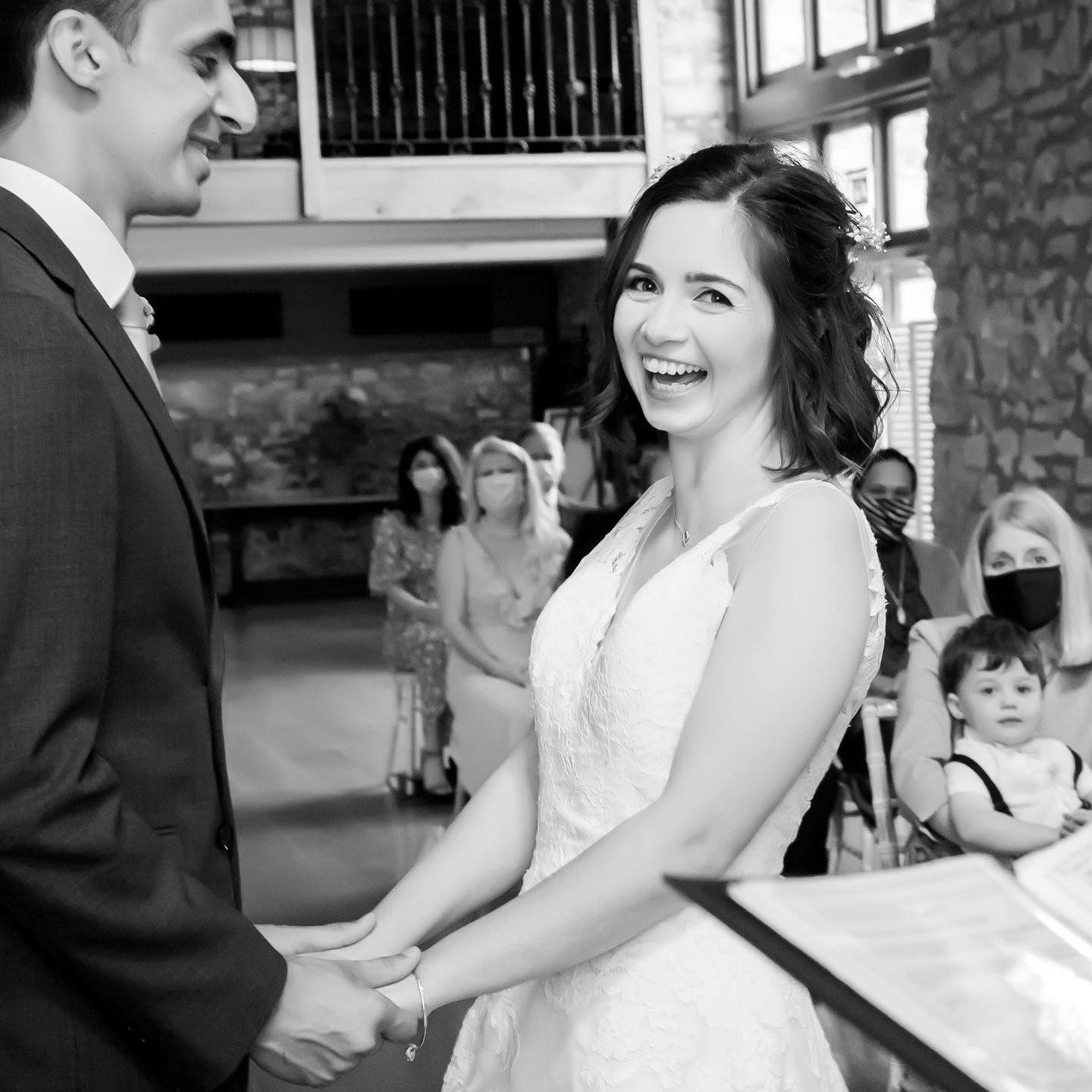 A black and white photo of a bride and groom holding hands