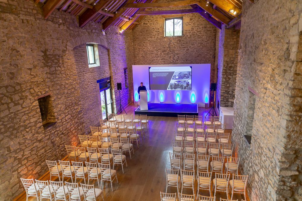 A large room with tables and chairs set up for a conference.