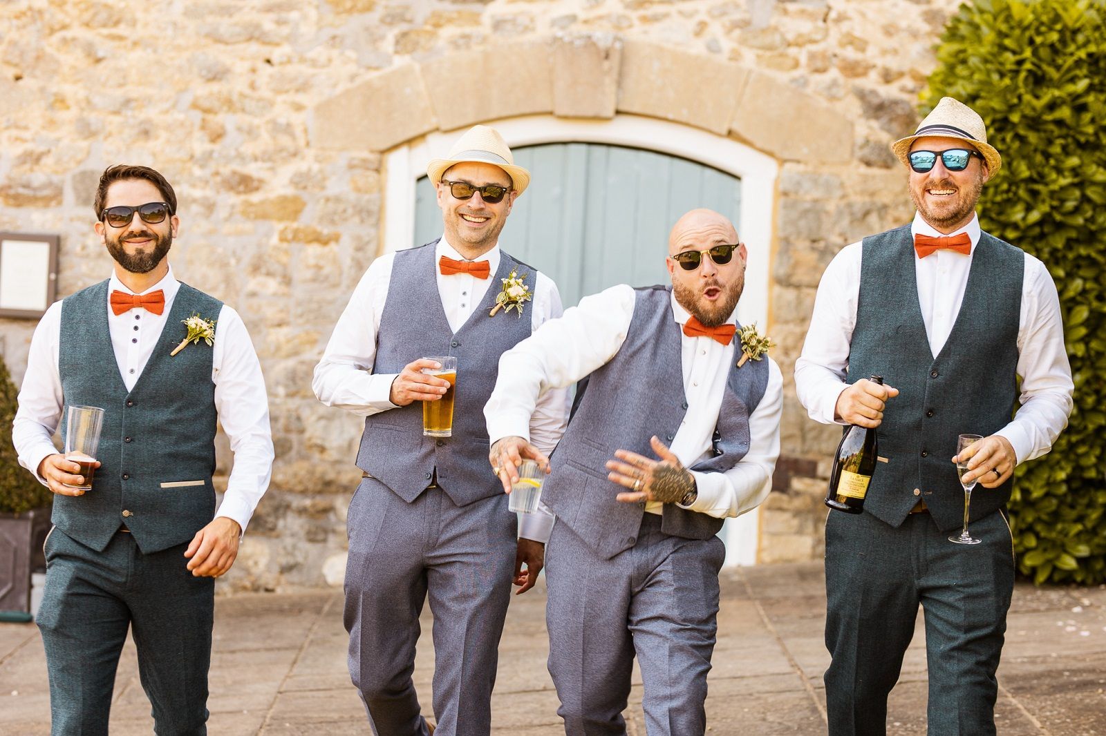 A group of men in suits and bow ties are walking down a sidewalk.
