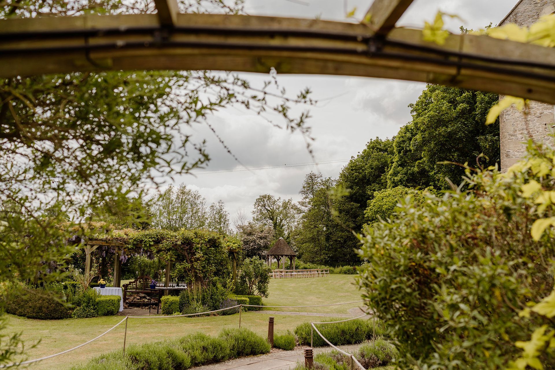 A view of a garden through a wooden archway.