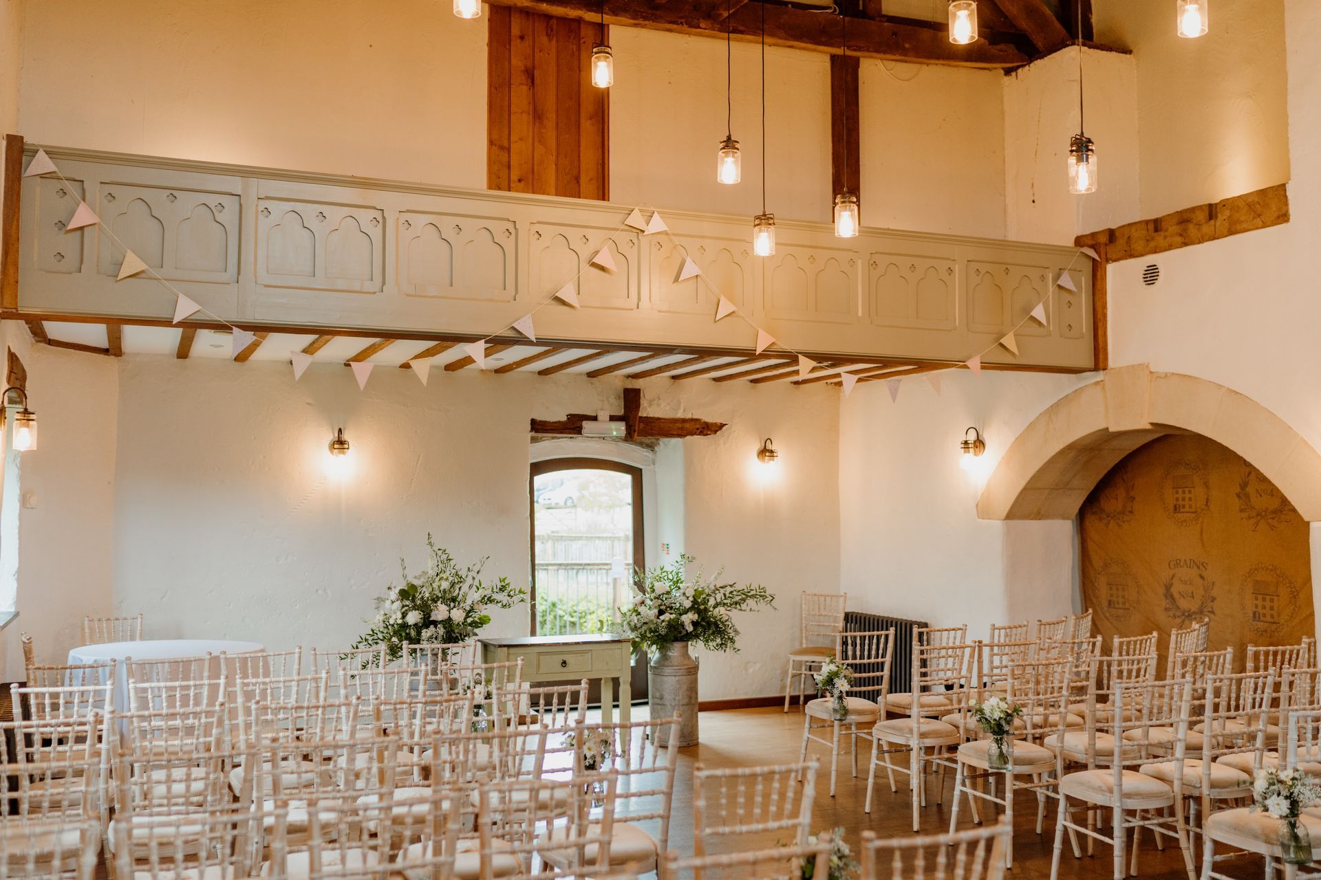 A room filled with chairs and flowers for a wedding ceremony.