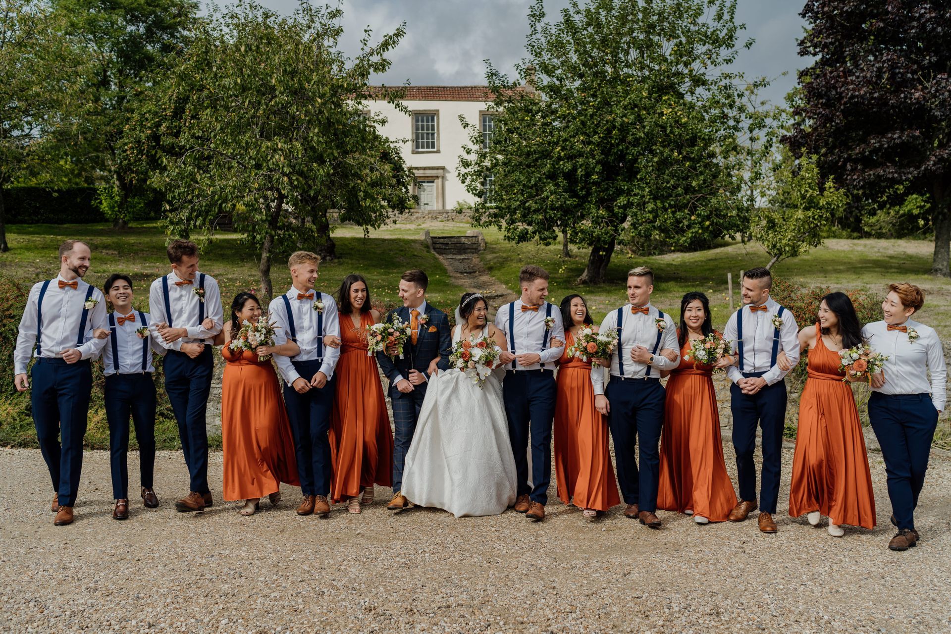 A bride and groom are posing for a picture with their wedding party.