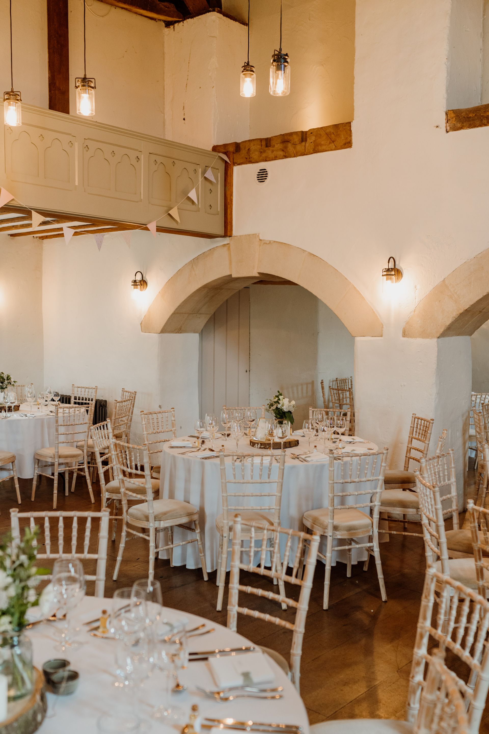 A large room with tables and chairs set up for a wedding reception.
