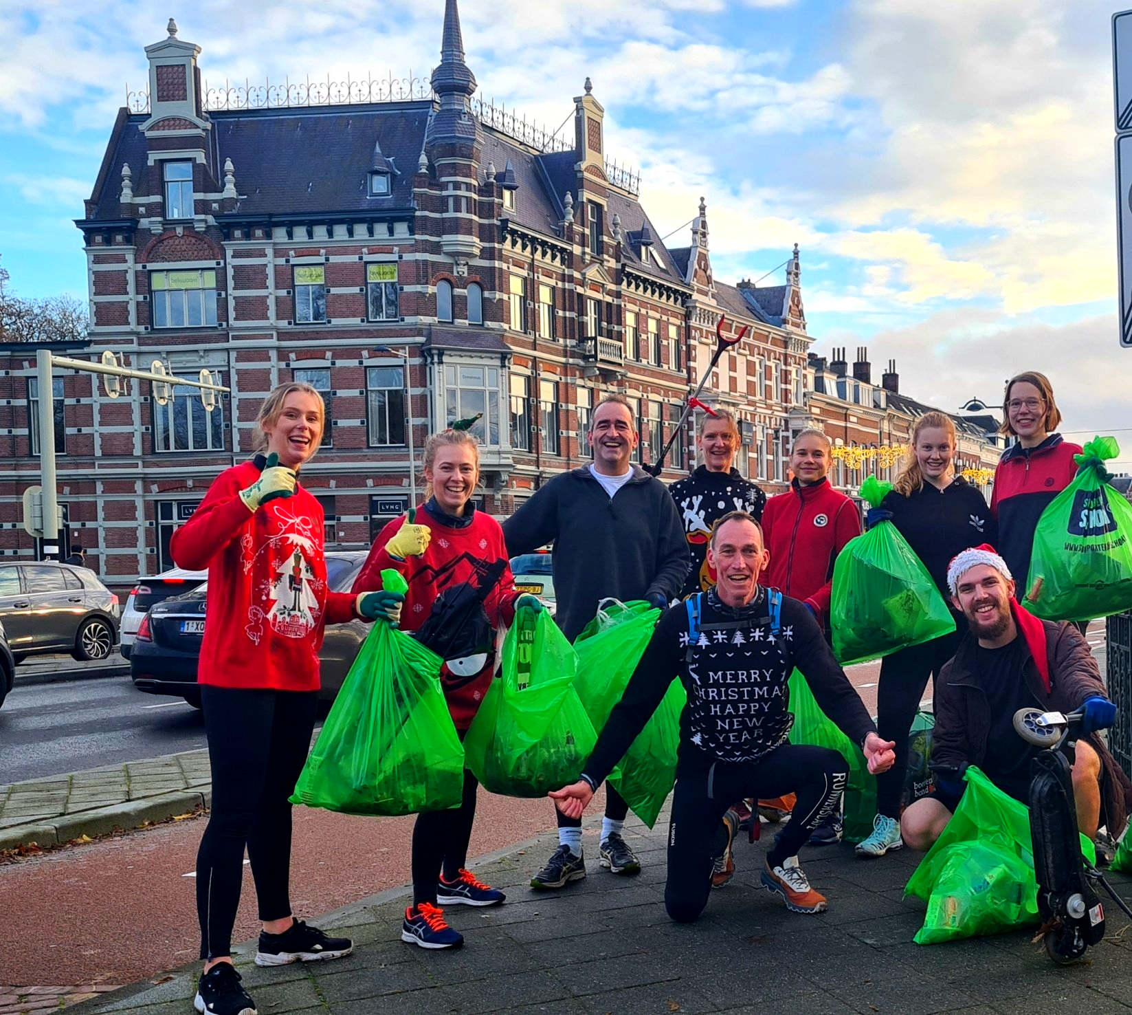 Sportieve zwerfafval opruimers in een kerstrui