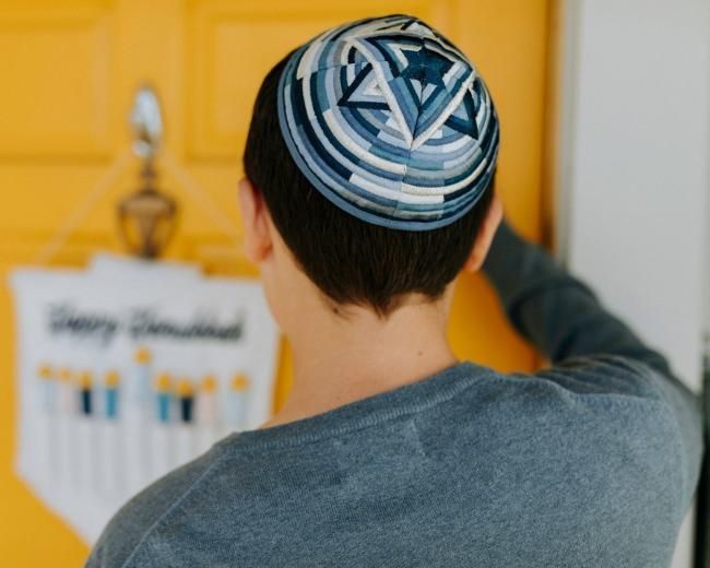 Man with kippah knocks on a door