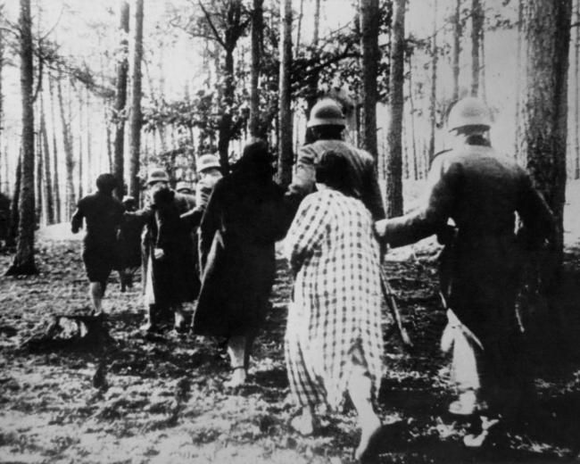 German atrocities in Poland ca. 1941. Polish women led by soldiers through woods to their execution during World War 2.