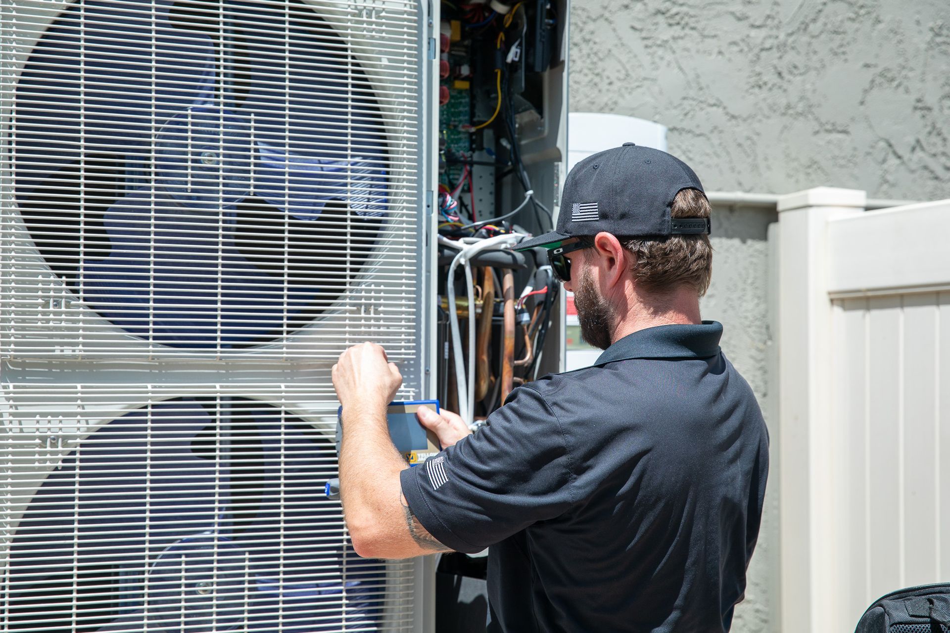 Williams Mechanical Co HVAC technician inspecting an outdoor AC unit.