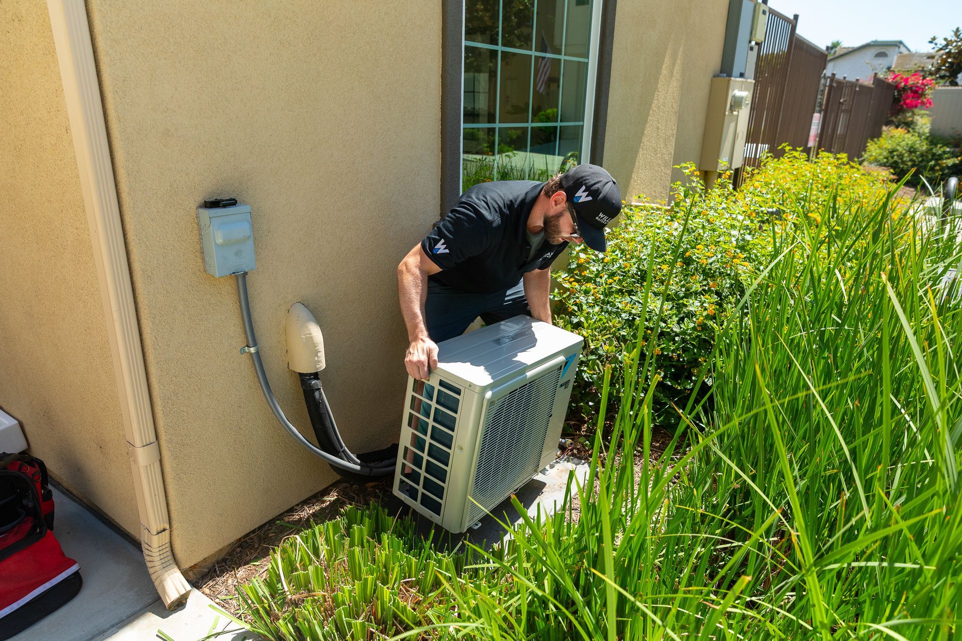 Williams Mechanical Co technician carrying a Daikin mini-split unit for installation