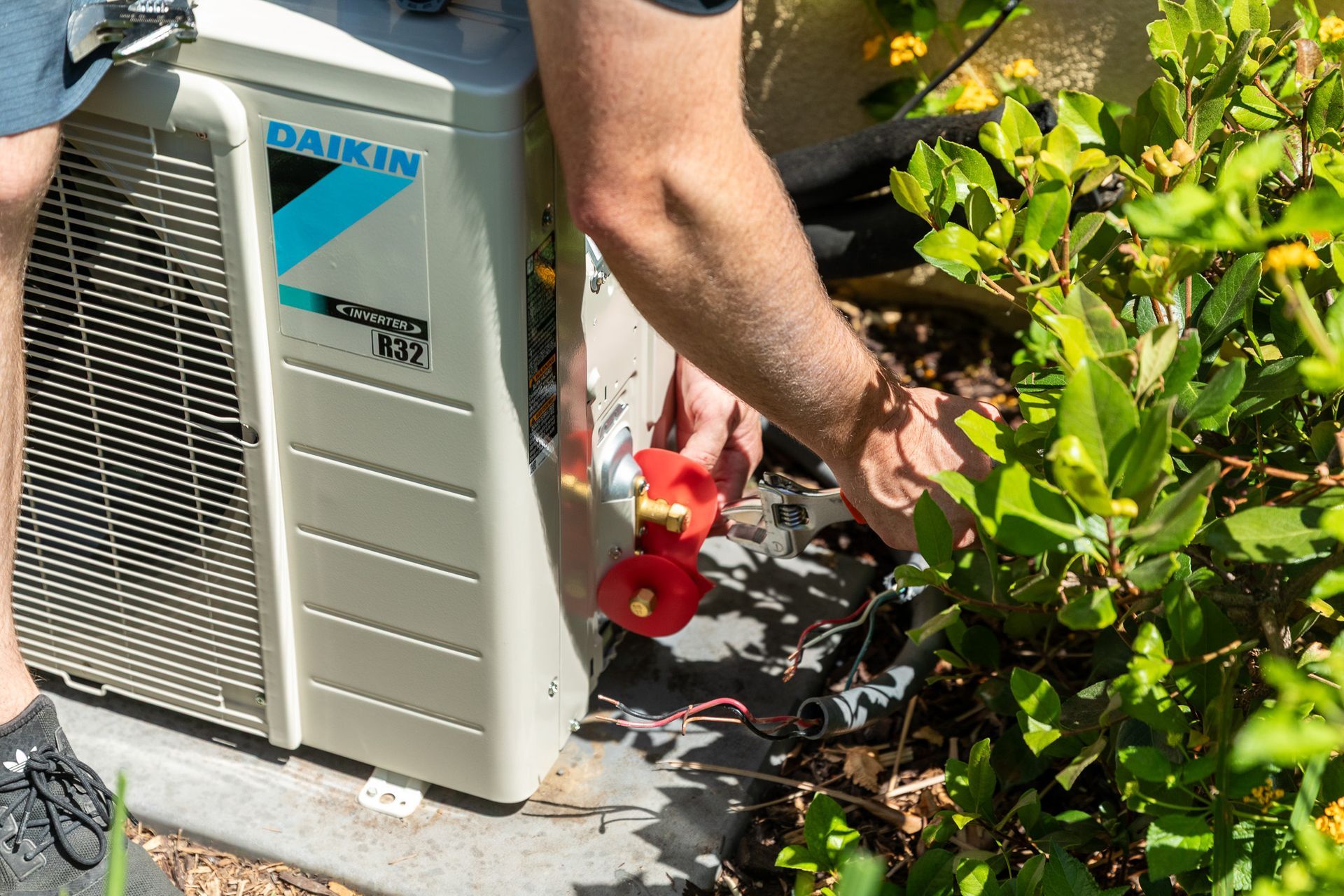Williams Mechanical Co technician working on a Daikin mini-split unit outdoors