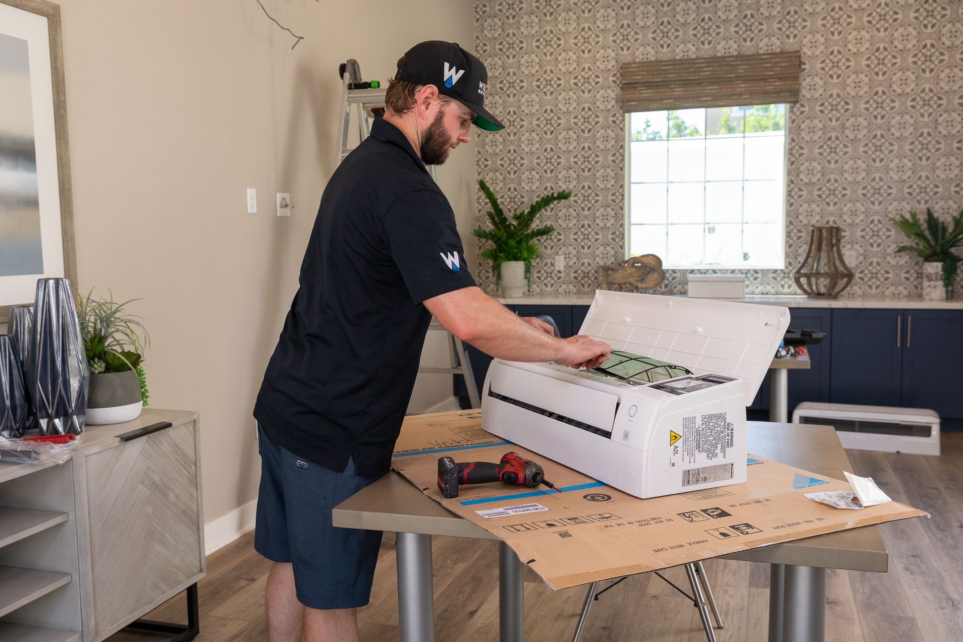 Williams Mechanical Co technician installing a mini-split AC unit indoors in San Diego