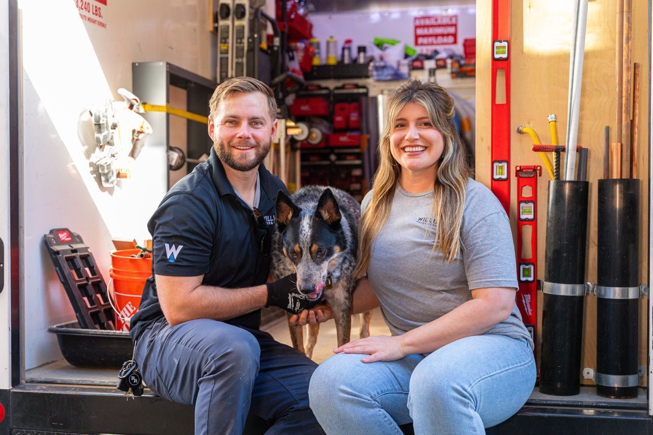 Tyler and Madi Williams of Williams Mechanical Co smiling in front of their work trailer