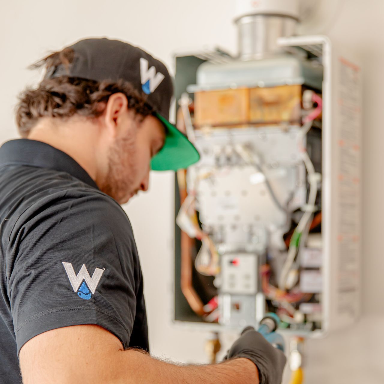 Williams Mechanical Co technician servicing an open tankless water heater