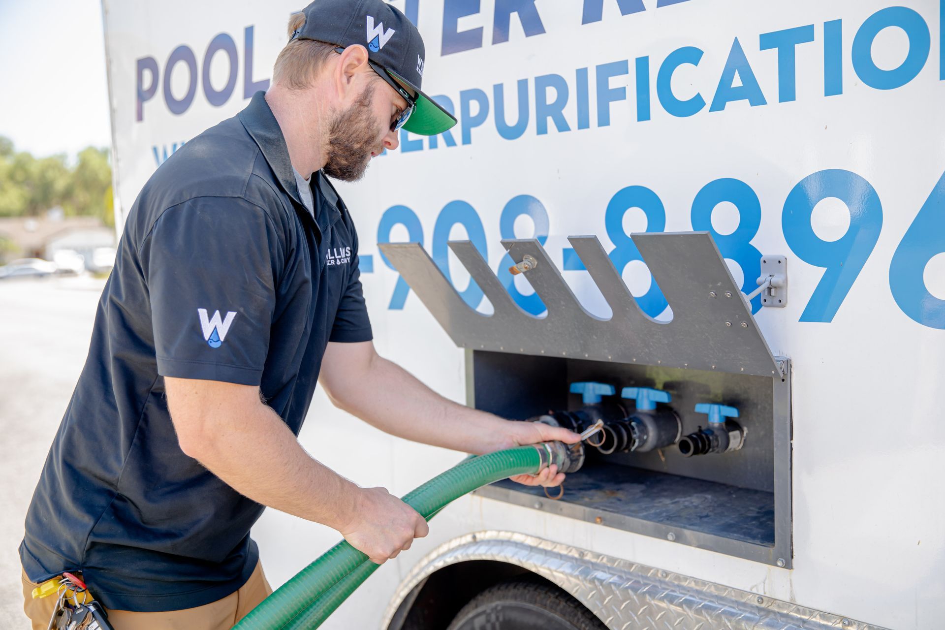 Williams Mechanical Co technician connecting a water hose to a purification system