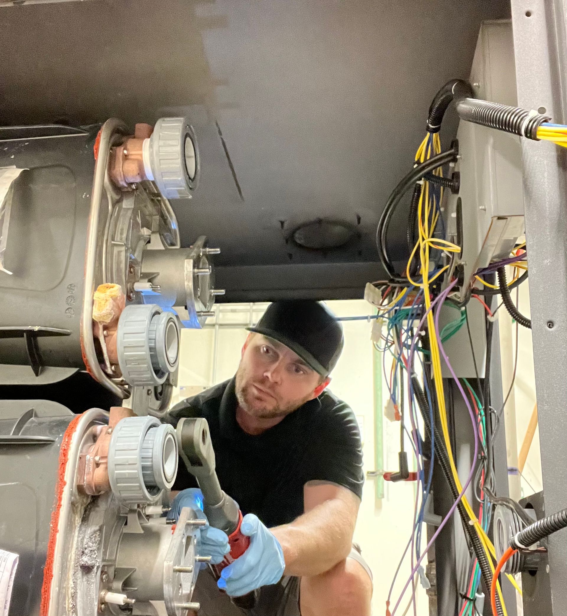 Williams Mechanical Co technician servicing a boiler with a wrench.