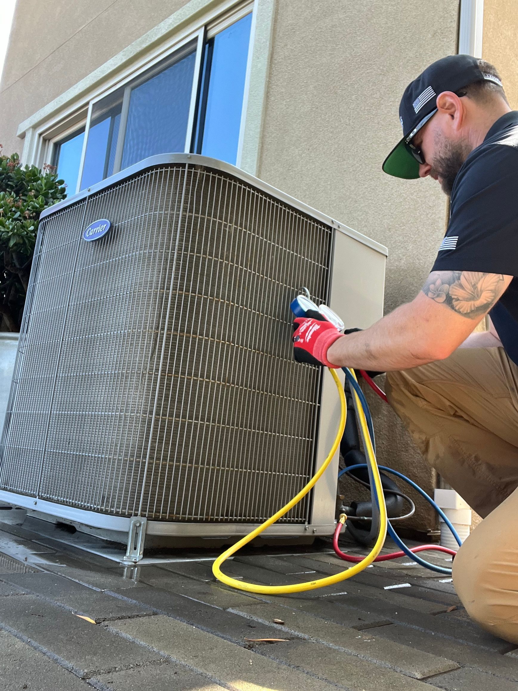 Williams Mechanical Co technician connecting hoses to an outdoor Carrier 410A 5 ton AC unit