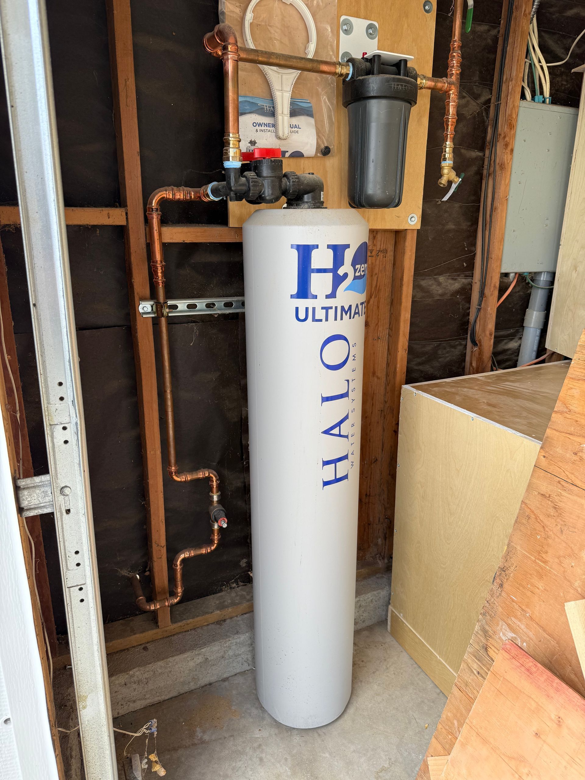 Halo Water filtration system with copper pipes, a gray tank, and filter in a utility space.