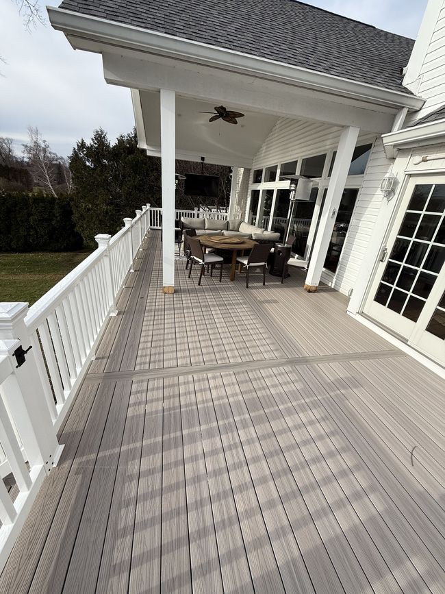 There is a large deck with a table and chairs on it.