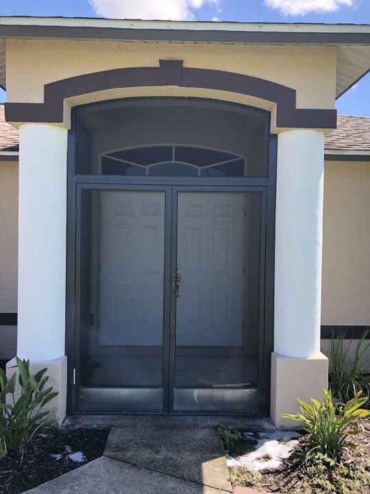 The front door of a house with a screened in porch.