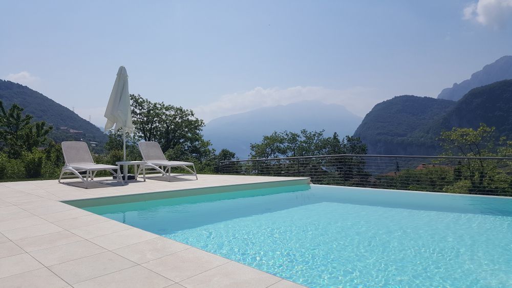 Pool with two lounge chairs and umbrella overlooking a mountain range — Tru Blu Pools & Spas in Bluewater, QLD