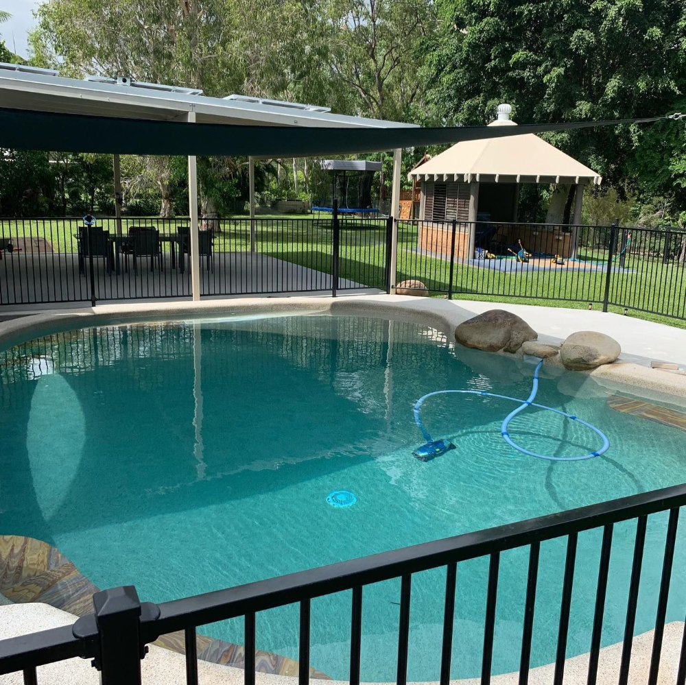 Swimming pool with black fence and shade structure. Gazebo in background— Tru Blu Pools & Spas in Bluewater, QLD