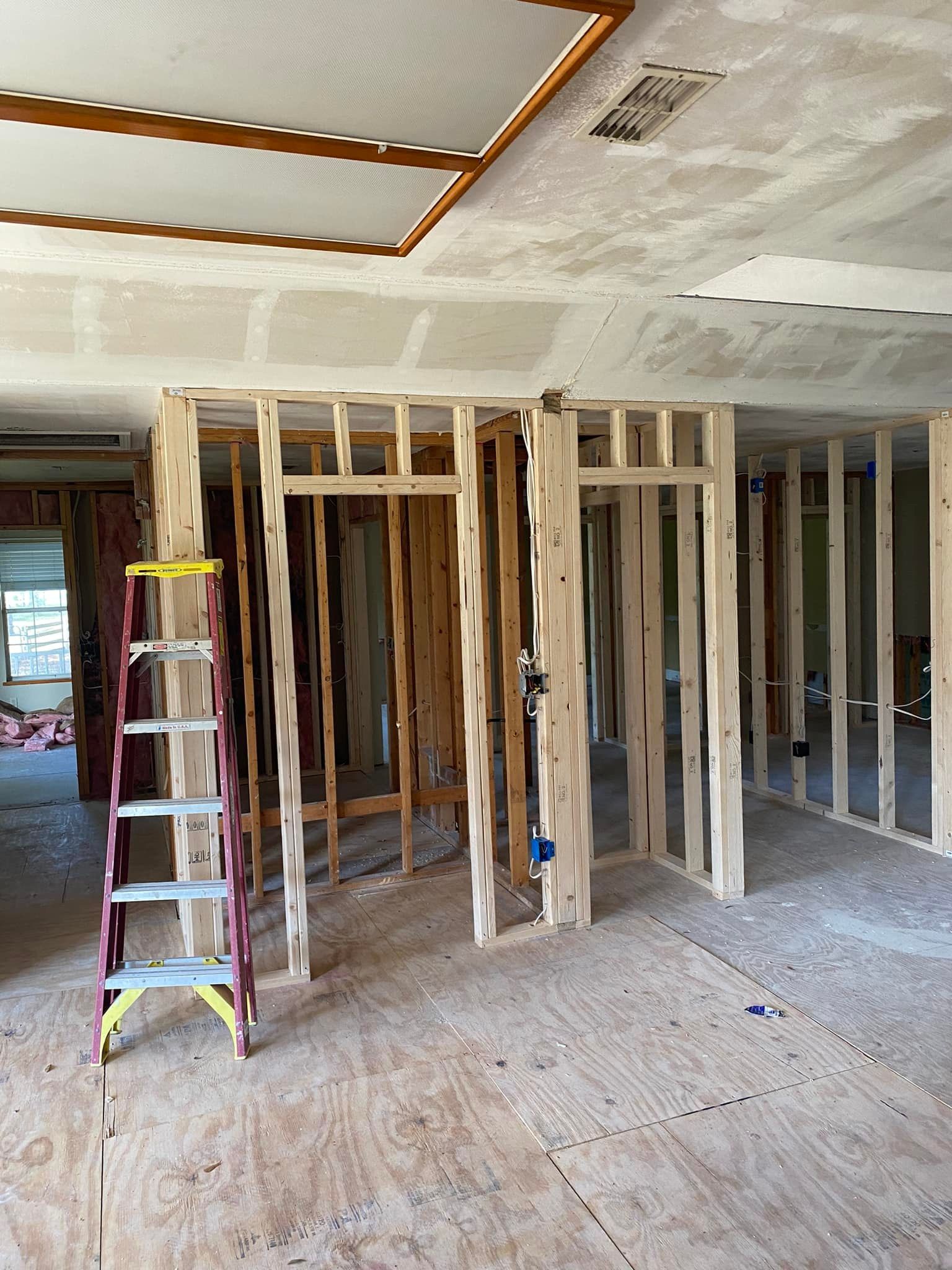 A ladder is sitting in the middle of a room under construction.