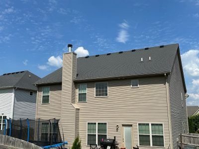 The back of a house with a trampoline in the backyard.