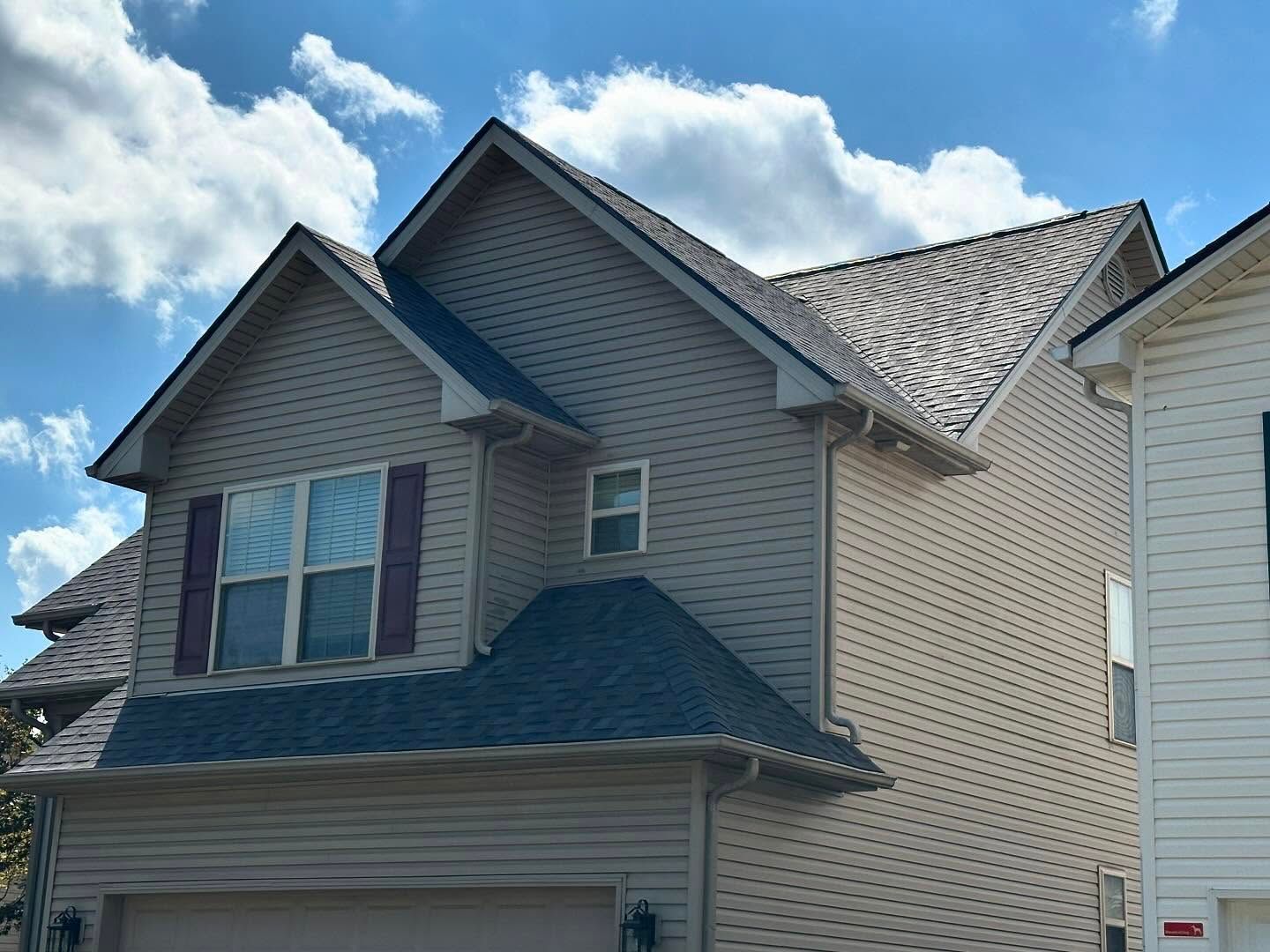 A house with a garage and a blue sky in the background.