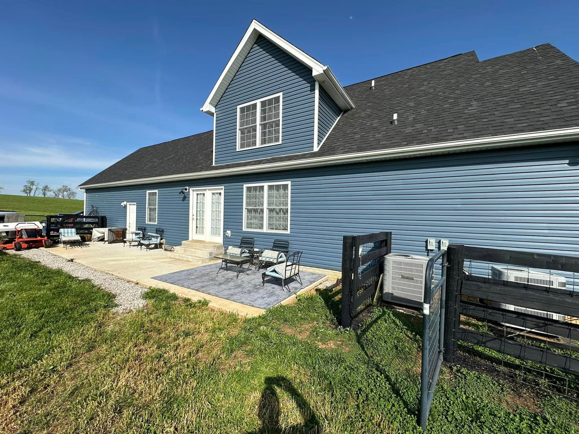 A blue house with a black fence in front of it.