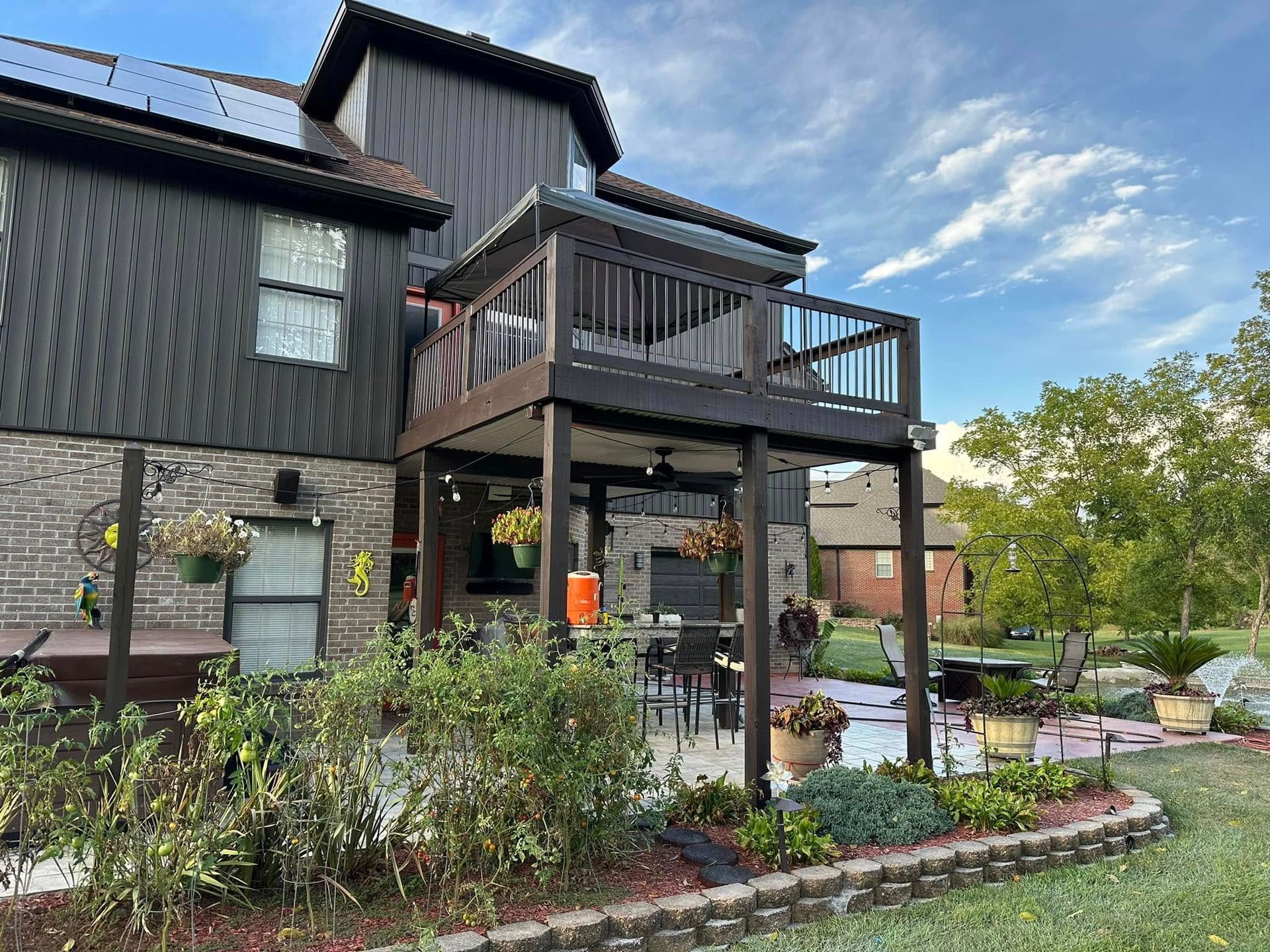 A large house with a large deck and patio in front of it.