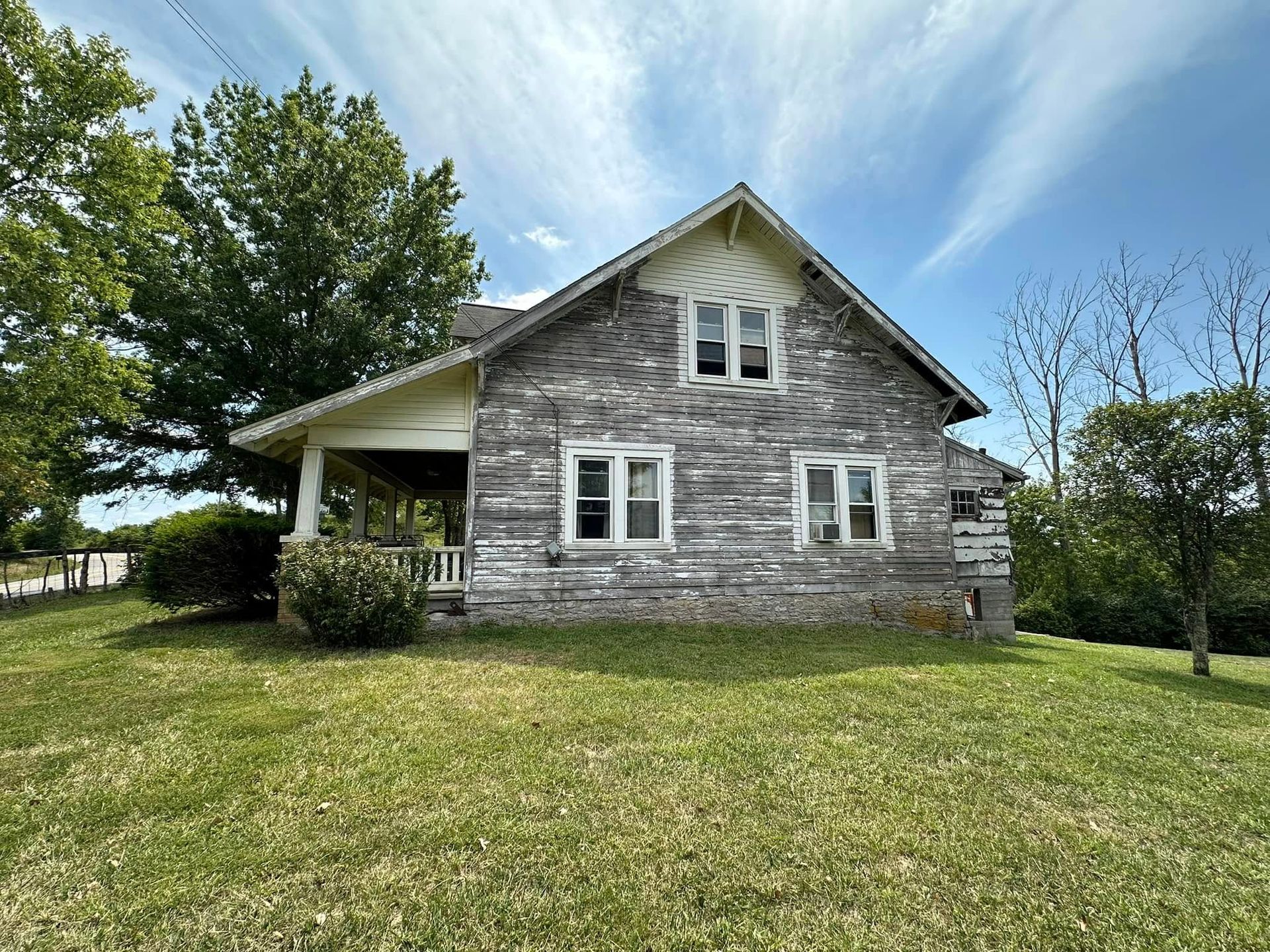 A small log cabin is sitting in the middle of a lush green field.
