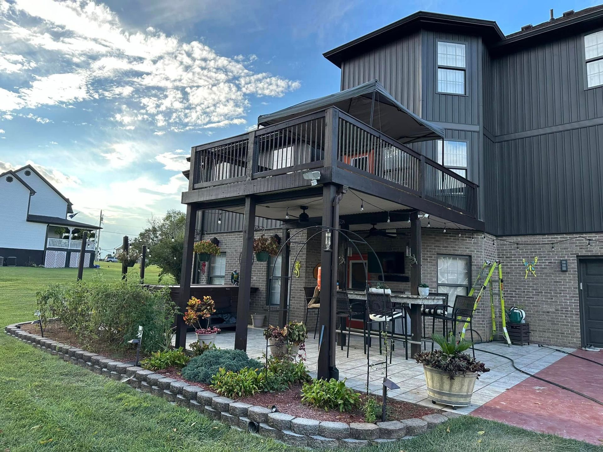 A large house with a large deck and patio in front of it.