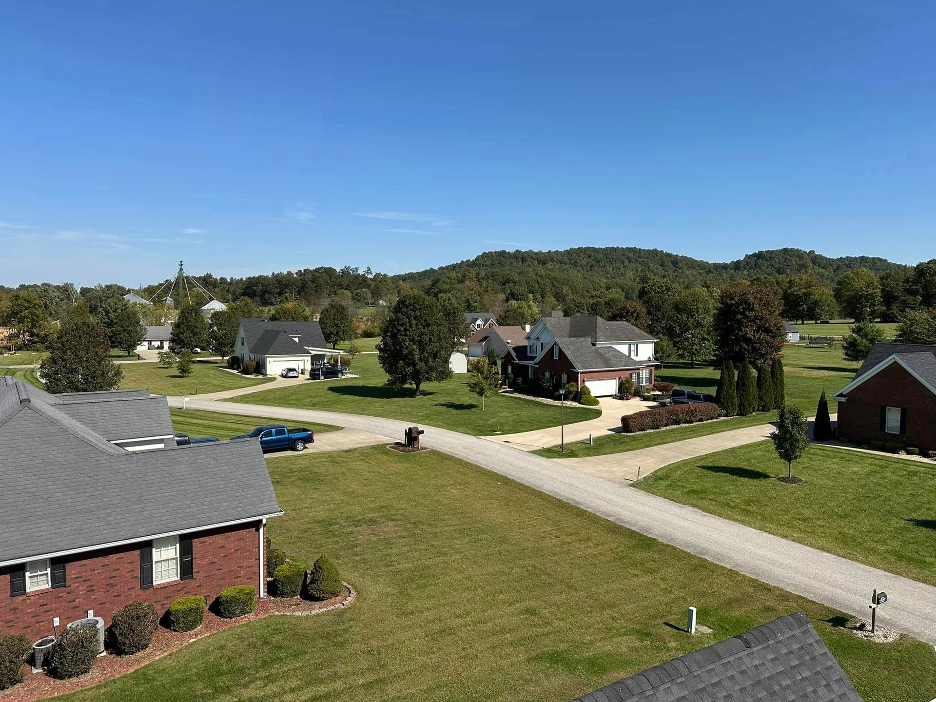 An aerial view of a residential neighborhood with houses and a dirt road.