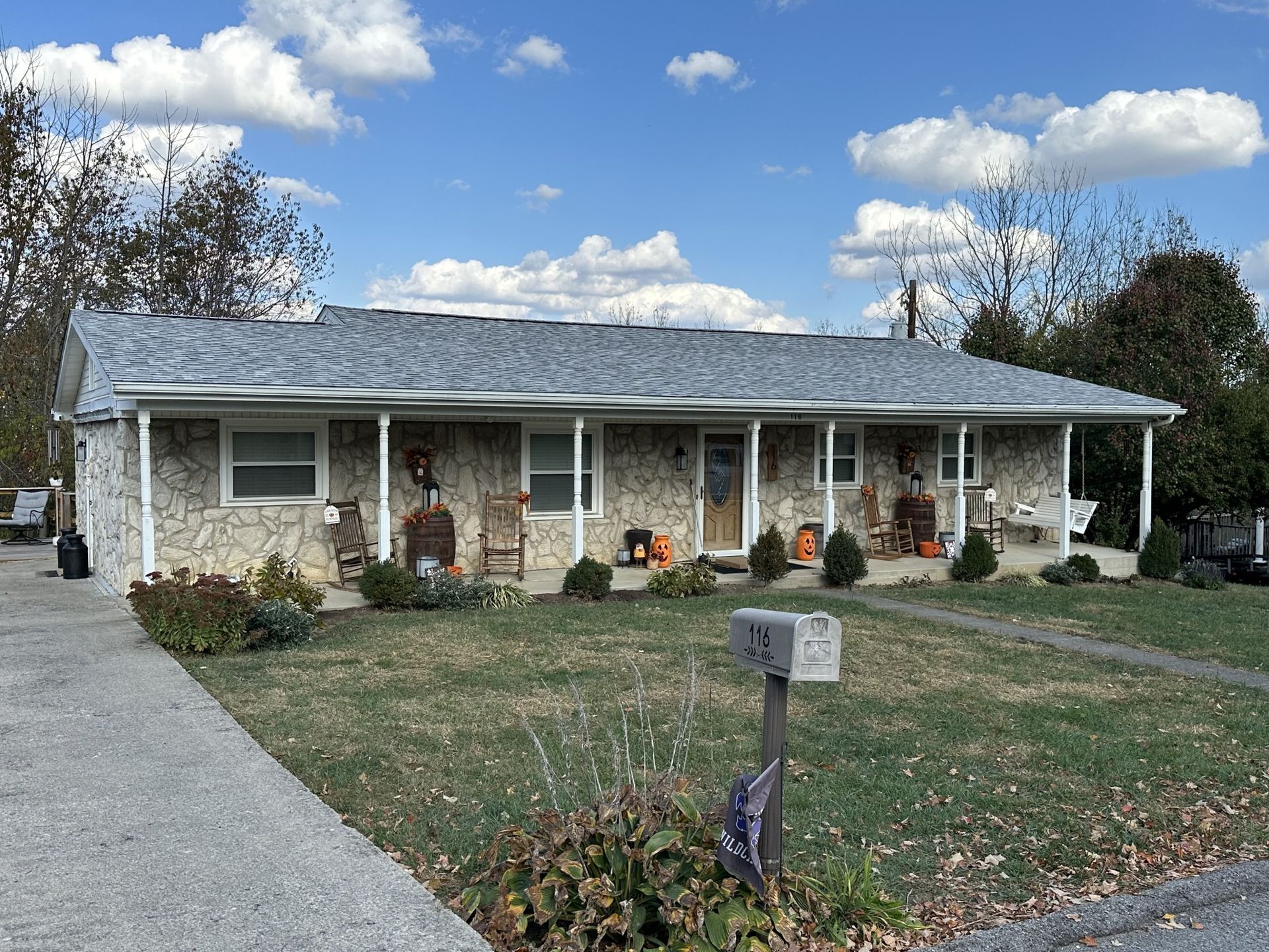 A house with a porch and a mailbox in front of it