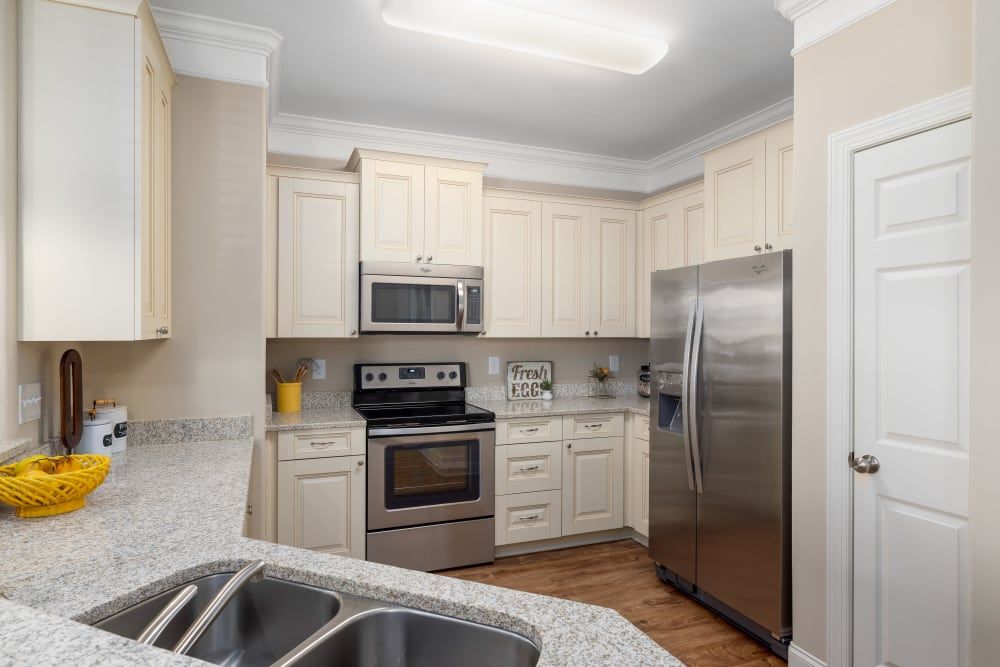 A kitchen with stainless steel appliances and granite counter tops at Marquis Ellis Crossing in Durham, NC.