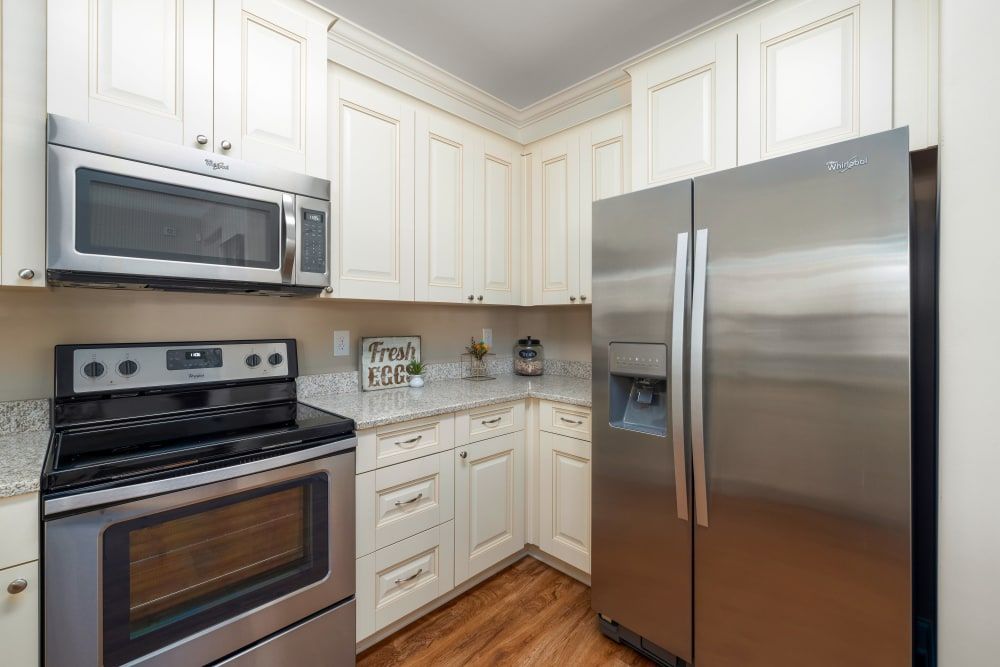 A kitchen with stainless steel appliances and white cabinets at Marquis Ellis Crossing in Durham, NC.