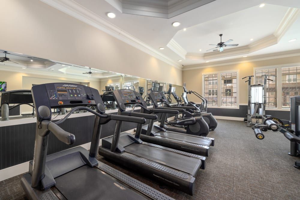 A gym with a lot of treadmills and exercise equipment at Marquis Ellis Crossing in Durham, NC
