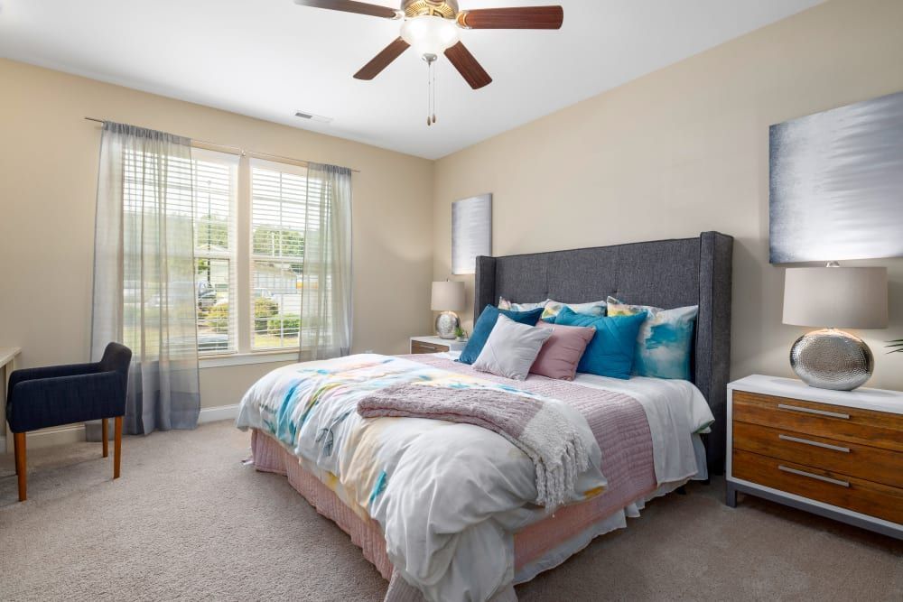 A bedroom with a large bed and a ceiling fan at Marquis Ellis Crossing in Durham, NC.