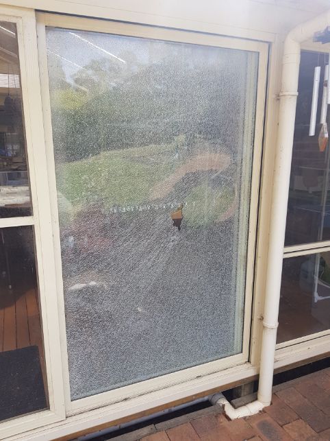 A Sliding Glass Door With a Reflection of a Person in the Window — Moss Vale Glass In Mittagong, NSW