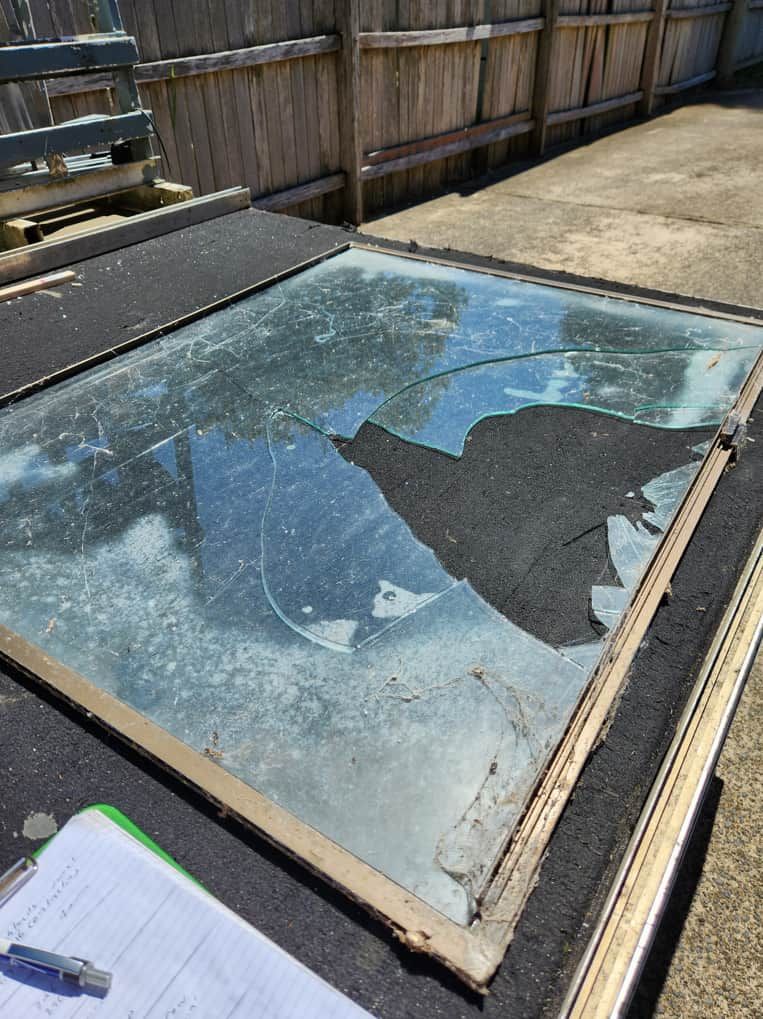 A Broken Glass Window is Sitting on Top of a Table — Moss Vale Glass In Bowral, NSW