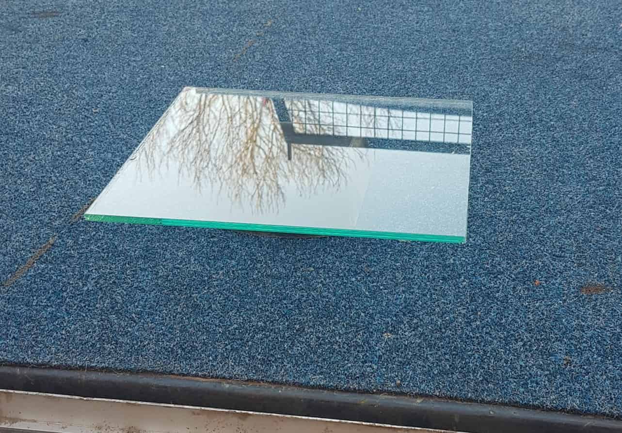 A Piece of Glass is Sitting on Top of a Blue Carpet — Moss Vale Glass In Moss Vale, NSW