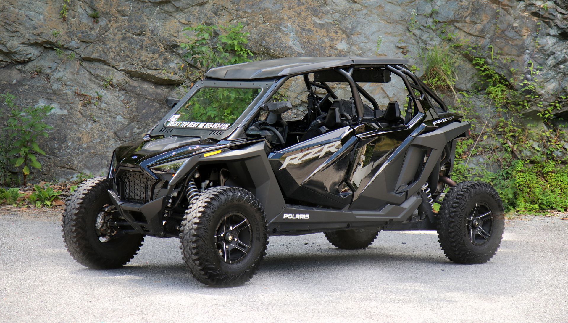 A blue and black atv is parked on the side of the road.