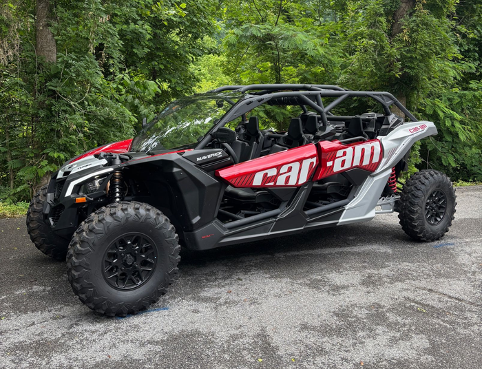 A white atv is parked on top of a grassy hill.