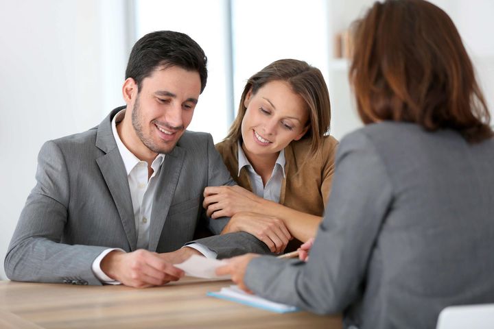 a man and a woman are sitting at a table talking to a woman