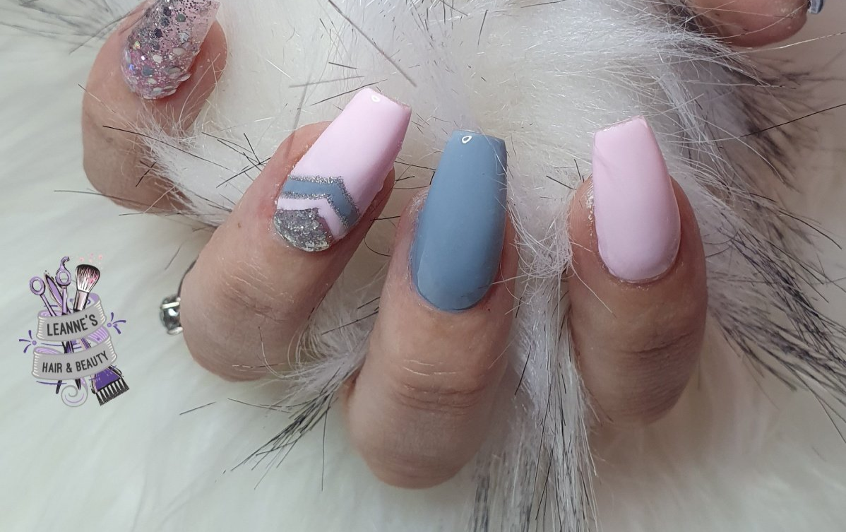 A close up of a person 's nails with a feather in the background.