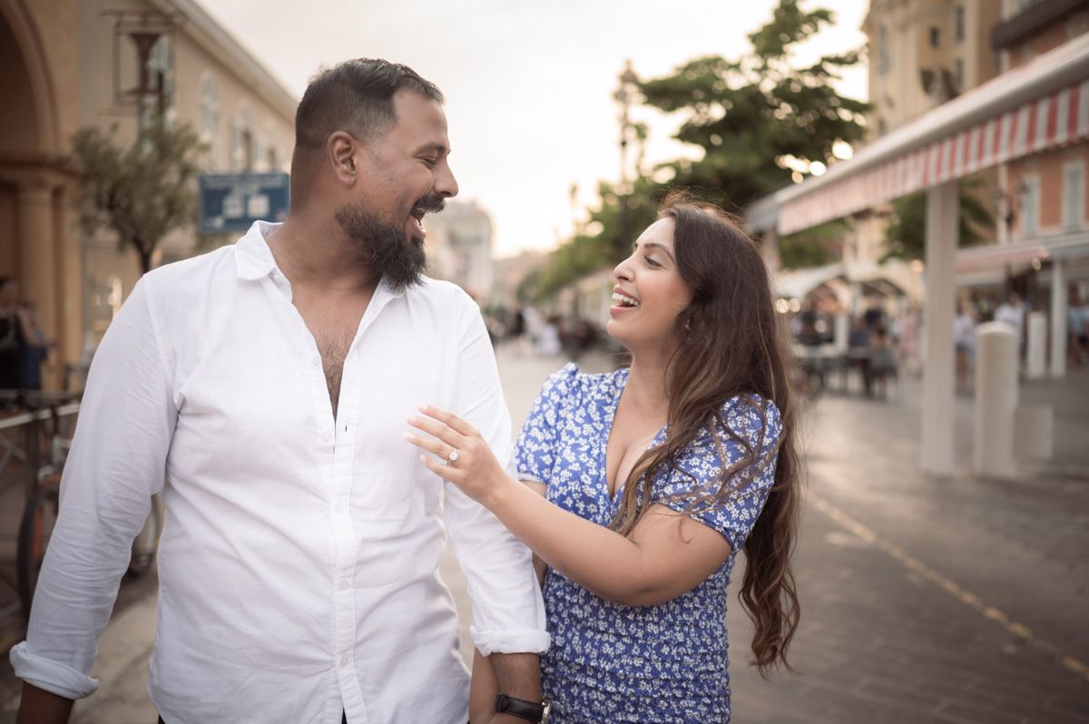 A couple laugh and smile during a stroll through the town's old town