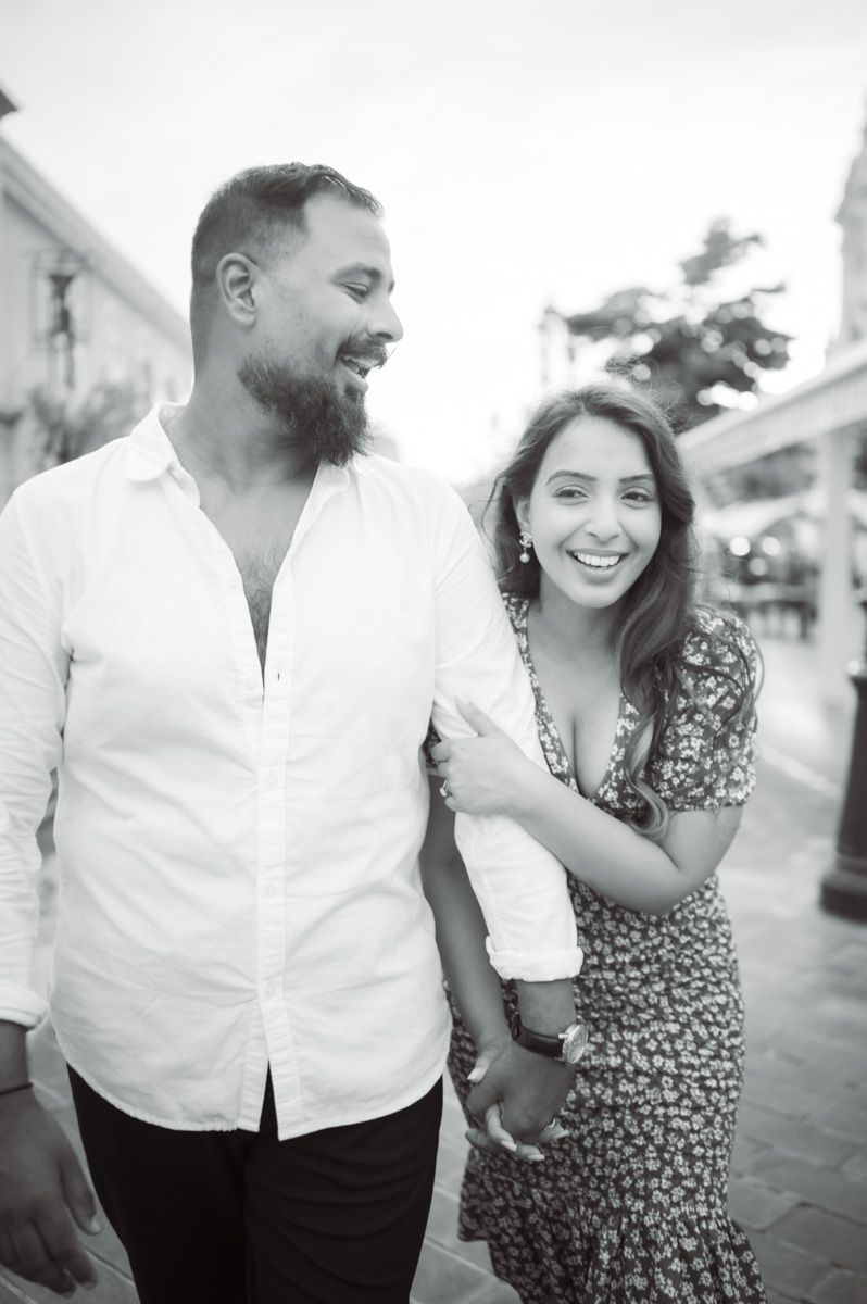 A couple during a couple photo session in Nice, France, walk down the town's famous Cours Saleya