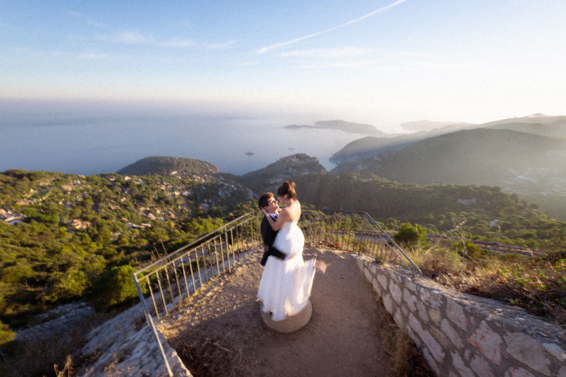 A husband spins his wife around durnig an elopement ceremony photographed at sunset on the French Riviera.